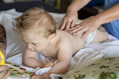 Baby with cerebral palsy having back massage in a rehabilitation