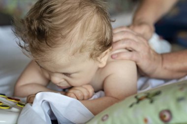 Baby with cerebral palsy having back massage in a rehabilitation