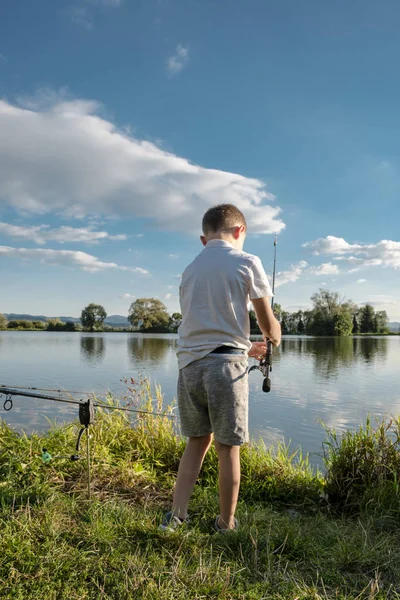 Niño pescando en un lago. Hermoso estanque de peces cerca de Badin, Banska Bystrica — Foto de Stock