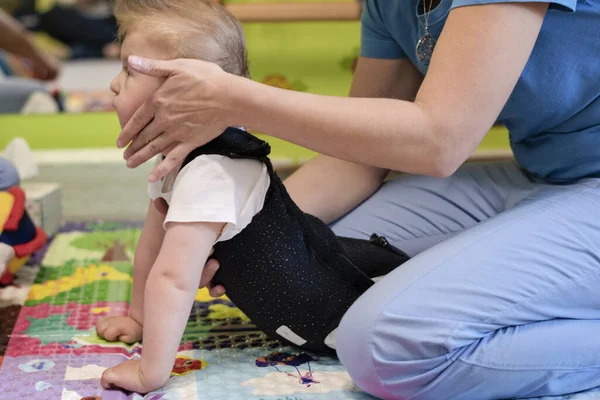 Çocuk terapi merkezinde fizyoterapi üzerine beyin felci geçirmiş bir çocuğun portresi. Özürlü çocuk rehabilitasyon merkezinde fizyoterapistlerle egzersiz yaparak terapi görüyor..