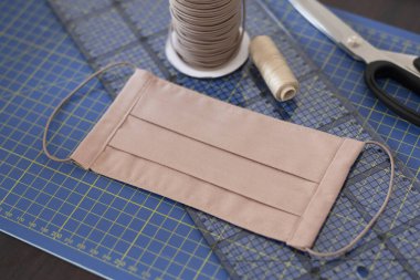 Dikiş aksesuarlarıyla el yapımı pamuklu kumaş yüz maskesi üzerinde titizlikle durun. Tükürük, öksürük, toz, kirlilik, virüs, bakteri, COVID-19 'a karşı koruma. 