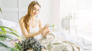 Güzel kadın müzik yatakta oturuyor