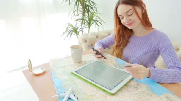 Une jeune fille rousse entre pensivement le numéro de carte de crédit dans le téléphone . — Video