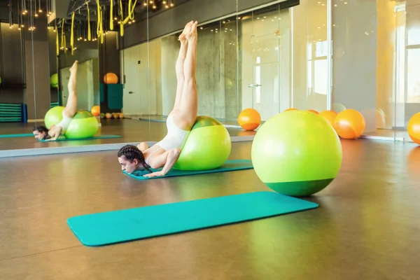 Acrobatics gymnast flexes stretched on fitness ball. — Stock Photo, Image