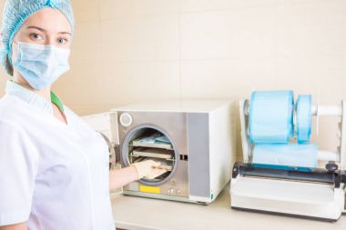 Tıbbi personel çalışan hemşire steril tıbbi aletleri çalışmaktan temizlik için cihazlar kullanılıyor.