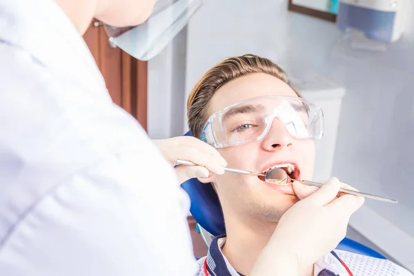 En stilig kille på en tandläkarens mottagning. — Stockfoto