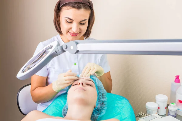 Profesional amable sonriente esteticista en el lugar de trabajo . — Foto de Stock