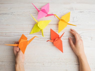 Turuncu ve sarı renkli kağıt origami figürleri. kadın el