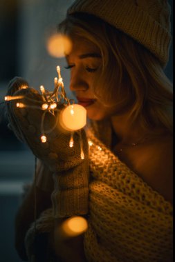 Çok güzel şık kadın kış öğe, dikey, ışıklar. Kış aksesuarları, şapka, eşarp ve sweater.shallow derinlik-in tarla ördü. Noel Kutlamaları ruh hali, mutlu anları