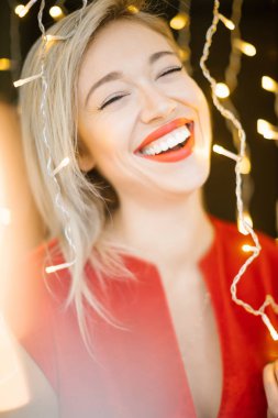 Mutlu parti kırmızı elbise ve dudaklar, şık kadın kutlama. Güzel büyük gülümseme. sığ derinlik-in tarla