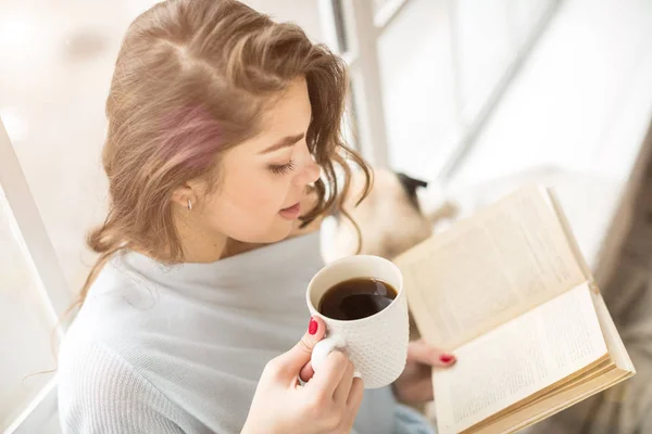 Book and drinks. Woman reading book white having a cup of fragrant coffee. Relaxed mood lovely hobby time. — Stock Photo, Image