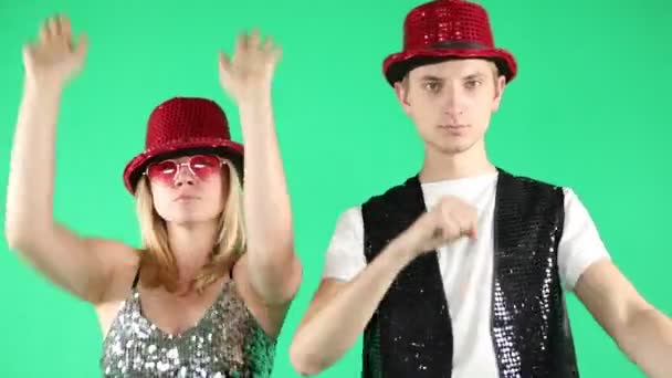 Active funny young couple dancing jumping and laughing with a funny gesture on green chroma key background. Video footage. Silly crazy happy mood — Stock Video