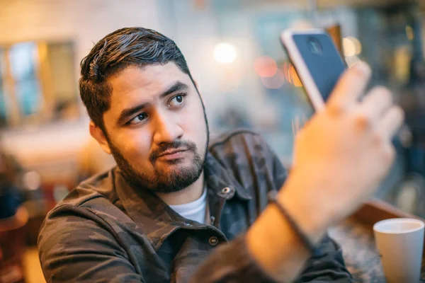 Beautiful latin man posing takes selfie on phone. Fun online dating communication. cheating cool face — Stock Photo, Image