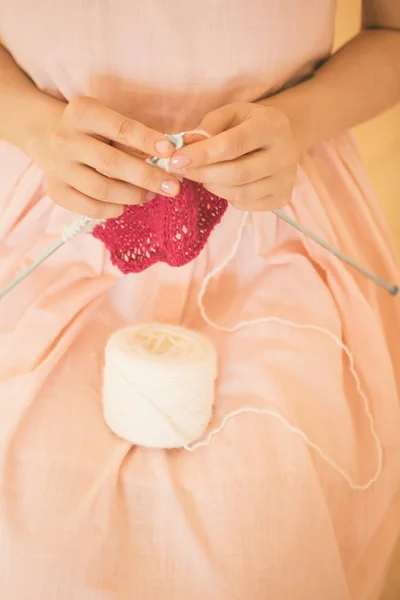 Handmade hobby de tricô. uma mulher tricota em agulhas. rosa e branco — Fotografia de Stock