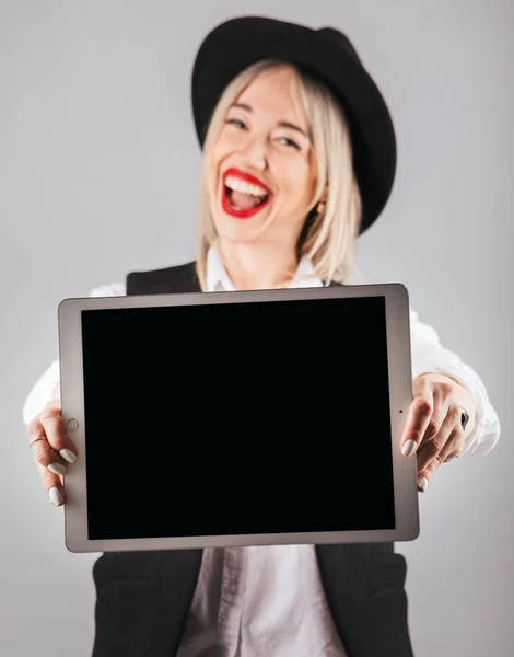 Улыбающаяся элегантная женщина в шляпе держит планшетный компьютер — стоковое фото
