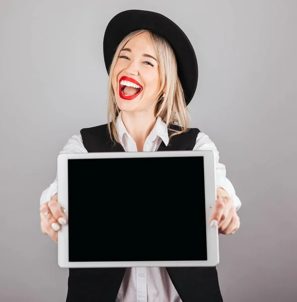 Mujer tonta feliz sosteniendo la tableta de ordenador mostrando la formación. Pantalla vacía puede colocarle texto o imagen —  Fotos de Stock