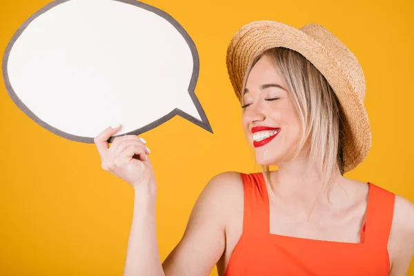 Happy relaxed woman in straw hat and red fancy dress is holding empty speech buble banners where you can place your information. Yellow background — Stockfoto