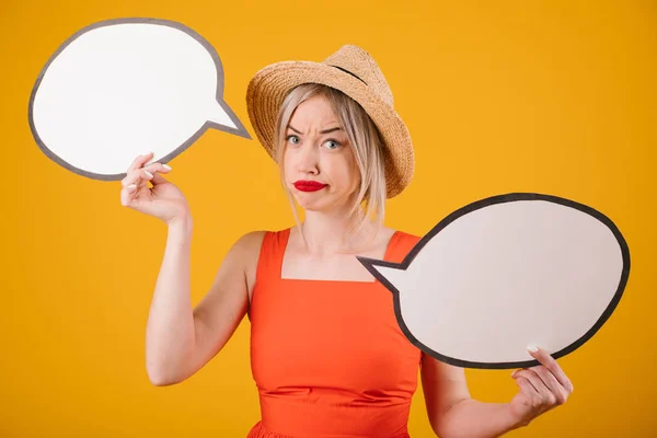 Dudando de las emociones de elección mujer en sombrero de paja y vestido de fantasía rojo está sosteniendo pancartas de la burbuja del habla. Fondo amarillo —  Fotos de Stock