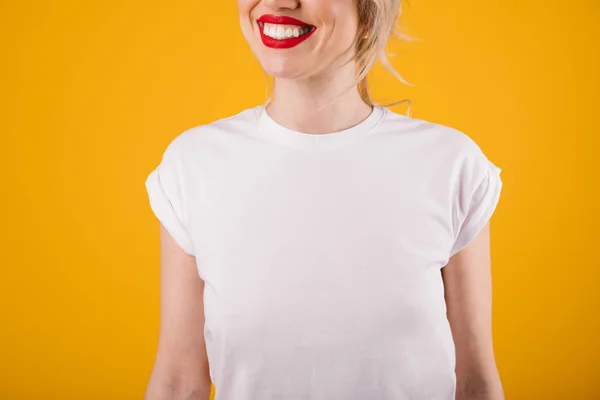 Mulher loira jovem sorridente em camiseta branca. Modelo. Fundo amarelo — Fotografia de Stock