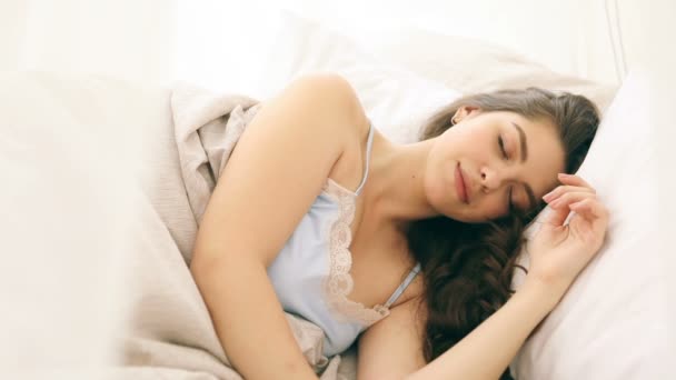 Jovem mulher bonita está dormindo sobre os lençóis confortáveis. Imagens de vídeo — Vídeo de Stock