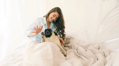çekici esmer kadın yatakta onu pug köpek ile oynarken. Bu güzel aile hafta sonu sabahları video görüntüleri