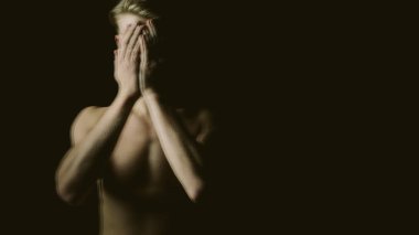 Creative emotional young naked man portrait. covering eyes with hands. Black background. triple exposure clipart