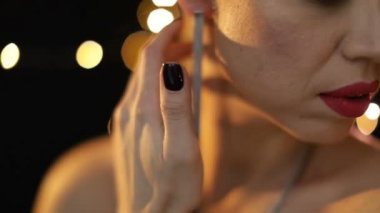 El ele tutuşan kadın duygusal bir şekilde boynunu ve omuzlarını tutuyor. Seksi gece aydınlatması. Video görüntüleri. Zarif küpe aksesuarları