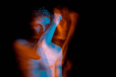 Yüzünün yanında el ele tutuşan adam. anlamlı, yoğun bir bakış. İntikam, dargınlık, kıskançlık, tehdit duyguları. Mavi ve turuncu tamamlayıcı renkler. Yaratıcı uzun pozlama serisi