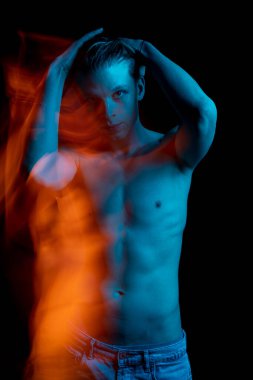 Kot pantolonlu genç çekici adam ellerini başının arkasında tutuyor. Kameraya bakıyorum. Özenli bir piercing bakışı. Tempt. Şüpheliyim. Acı. Bedava turuncu deniz mavisi rengi. Bilinçaltının gösterimi 