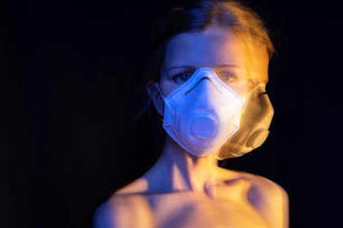 Maskeli, çıplak omuzlu, hassas, zayıf bir kadın. Hassasiyet ve korunma ihtiyacı. Uzun pozlama kavramsal fotoğraflar. Gergin bir bakış. Üzücü duyguları karantinaya alın. Virüsten kişisel koruma