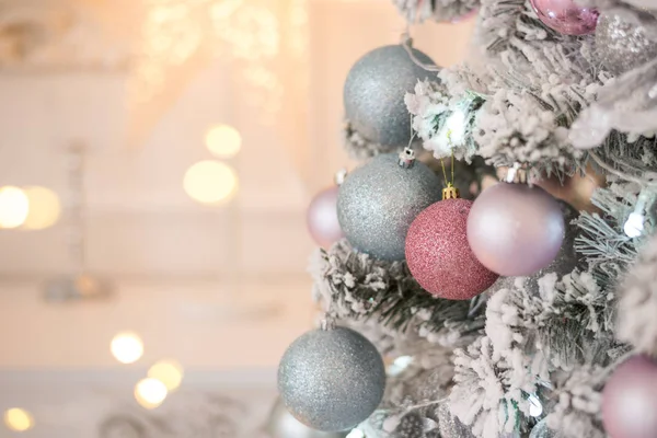 Noel, xmas, yeni yıl pembesi ve turkuaz kürk ağacı süslemesi toplar, papyonlar, kurdeleler, pembe ışıkta çiçekler