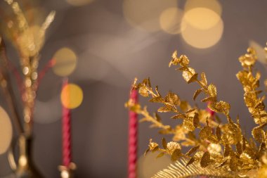 Noel arkaplanındaki altın dallar Noel ışıkları ve mumlarının arka planında