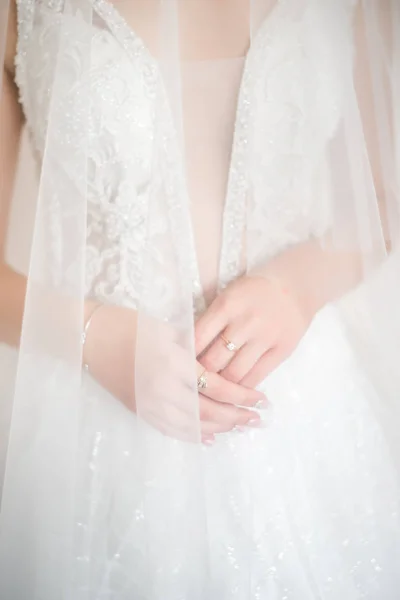 De handen van de bruid met gouden trouwring met diamant. Bruid Voorbereidingen. Bruiloftsmorgen. Juwelen. Manicure van dichtbij. Betrokkenheid. Het knoopsgat met bloemen. — Stockfoto