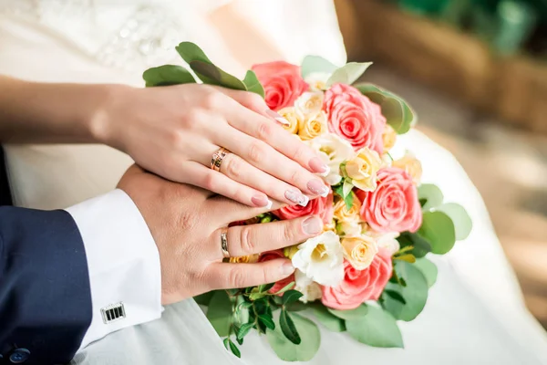 Händer brud och brudgum med ringar på bröllopsbukett. Äktenskapsbegrepp. — Stockfoto