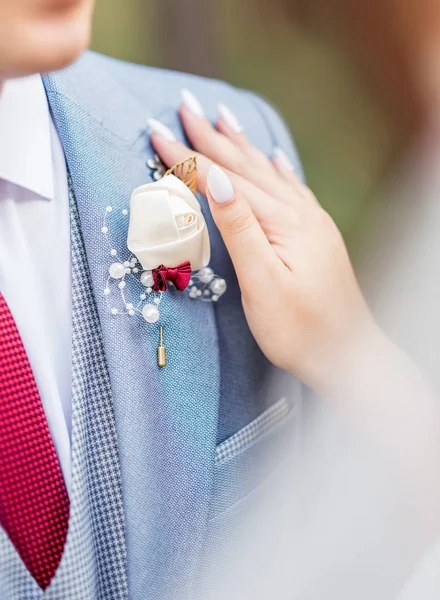 Bride clings to the jacket of the groom's boutonniere of flowers — Stock Photo, Image