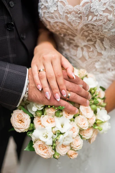 Manos de novia y novio con anillos en el ramo de bodas. Concepto de matrimonio —  Fotos de Stock