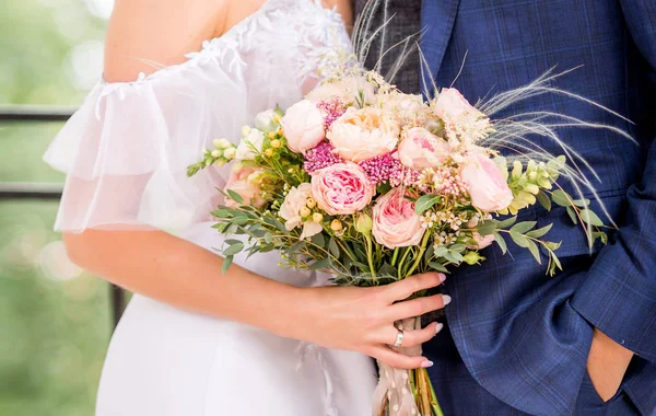 Nevěsta a ženich drží krásné svatební kytice květin — Stock fotografie