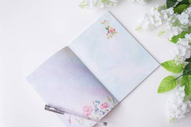 Not defteri olan bir arka planda bahar ve yaz çiçekleri