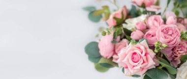 Hafif arka planda güzel gül çiçekleri. Yumuşak renklerde çiçekli çerçeve, yazı için beyaz alan. Anneler Günü ve Sevgililer Günü için tebrik kartı için sanat çiçeği arkaplanı