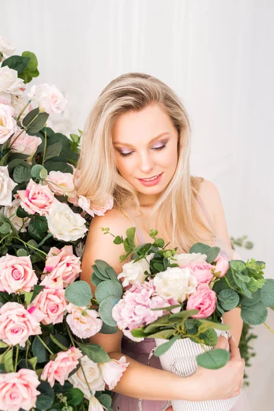 Beautiful romantic young woman with natural makeup posing against a background of flowers. The girl is blonde with a clean look and a beautiful smile.Close-up portrait. Perfume and cosmetic concept — Stock Photo, Image