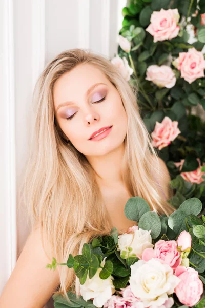 Krásná romantická mladá žena s přirozeným make-up pózovat na pozadí květin. Dívka je blondýnka s čistým vzhledem a krásným úsměvem. Parfém a kosmetický koncept — Stock fotografie