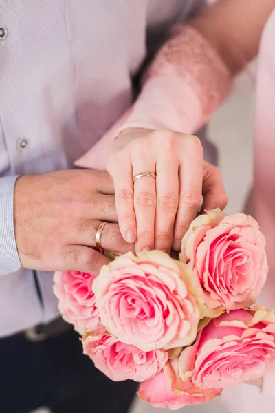 Hände Von Brautpaaren Auf Dem Hintergrund Des Hochzeitsstraußes Goldene Eheringe — Stockfoto