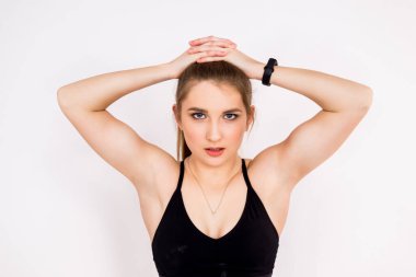 Beyaz arka planda bir fitness kadınının yakın plan portresi. Sportif bir kızın güçlü kolları ve omuzları..