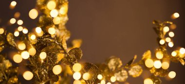 Kahverengi arka planda altın desenler. Bokeh ışıkları yeni yıl afişinde.