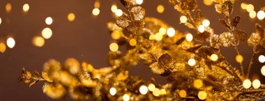 Kahverengi arka planda altın desenler. Bokeh ışıkları yeni yıl afişinde.