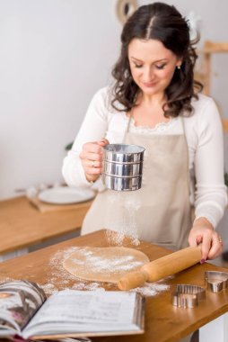 Kadın aşçı hamuru dışarı atıyor. Kurabiyeler için kurabiye hazırlığı. Ev yapımı kek.