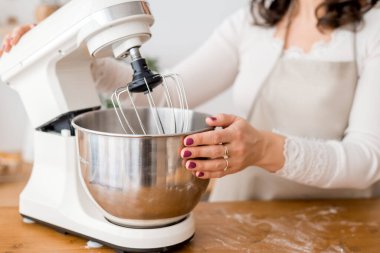 Büyük bir mikseri tutan kadınların ellerine yakın çekim.