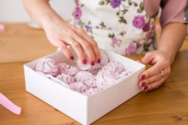 Ev yapımı marşmelov paketlemesi. Marshmallow hediye kutusuyla kadın eli..