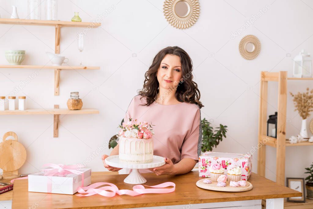 A housewife a woman pastry chef in the kitchen prepared a cake and a sweet dessert.