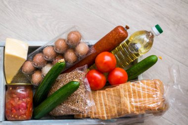 Bağış için birçok farklı ürünle kutunun yakın görüntüsü. Coronavirus bağış kutusu konsepti. Seçici odak /